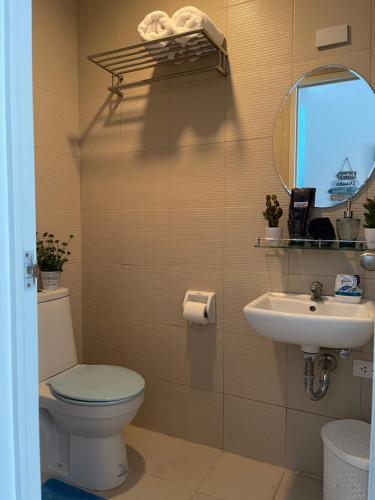 a bathroom with a toilet and a sink and a mirror at Casa Ayesha Sweet Staycation at La Bella Tagaytay in Tagaytay