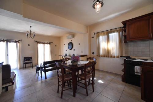 a kitchen and dining room with a table and chairs at Toxotis Villas in Armenistis