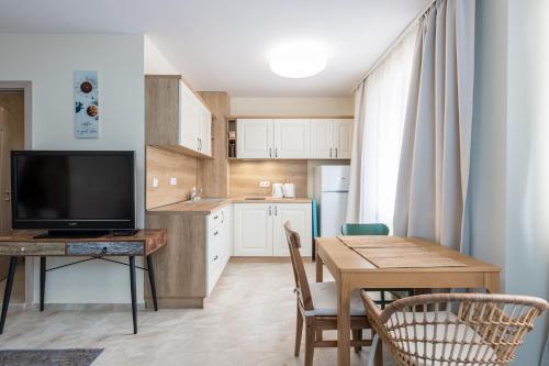 a kitchen and dining room with a table and a television at Turquoise in Pomorie