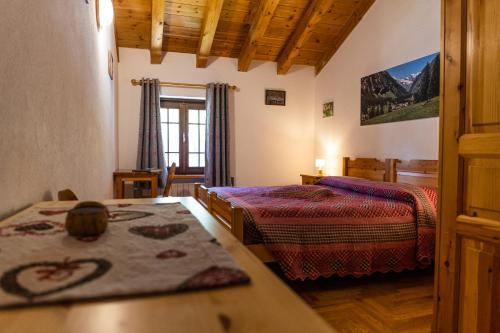 a bedroom with two beds and a table and a window at Lou Tsantelet in Cogne