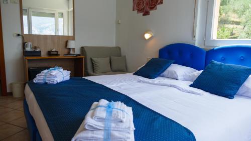 a bedroom with two beds with blue pillows at Hotel Casa Marinella in Malcesine