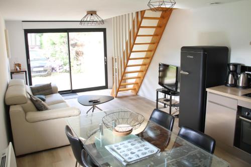 - un salon avec une table en verre et un escalier dans l'établissement Villa Atlantique, à Assérac