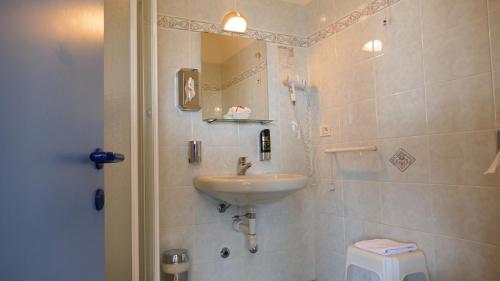 a bathroom with a sink and a mirror and a toilet at Hotel Casa Marinella in Malcesine