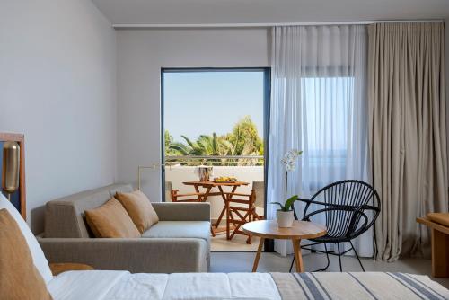 Smy Kos Beach & Splash في ماستيخاري: غرفة معيشة مع أريكة وطاولة