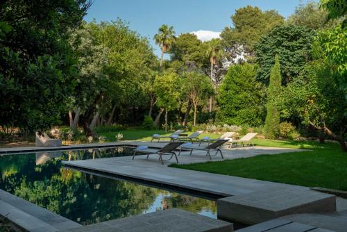 un jardín con piscina, sillas y árboles en Palazzo Donna Elisabetta, en Manduria