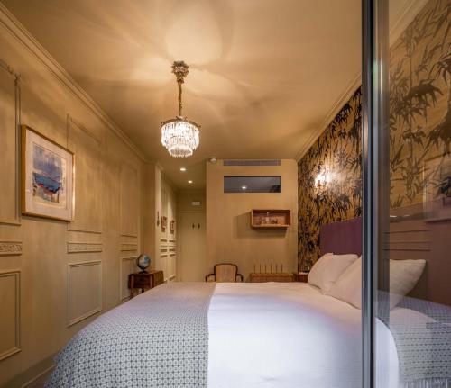 a bedroom with a large bed and a chandelier at toctoctoc lisboa in Lisbon