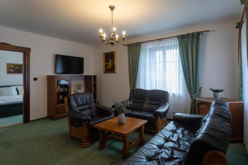 a living room with a couch and chairs and a television at Hotel Zámeček Pod Hradem Starý Jičín 111 in Starý Jičín