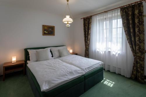 a bedroom with a large bed and a window at Hotel Zámeček Pod Hradem Starý Jičín 111 in Starý Jičín