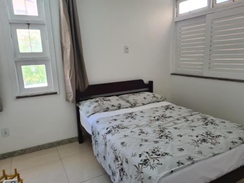 um quarto com uma cama com um edredão preto e branco em Cajueiro's House em Aracaju