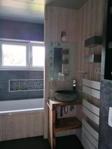 a bathroom with a tub and a sink and a bath tub at les rainettes in Grand-Halleux