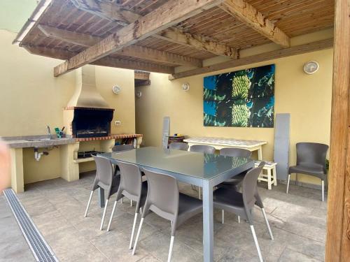 une salle à manger avec une table, des chaises et une cheminée dans l'établissement Vivienda Vacacional TINIZARA, à Arona