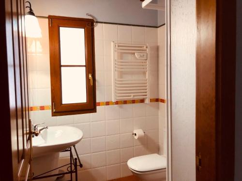 baño con aseo y lavabo y ventana en Apartamentos San Francisco Rural, en Caño