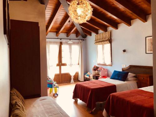 Un dormitorio con dos camas y una lámpara de araña. en Apartamentos San Francisco Rural, en Caño