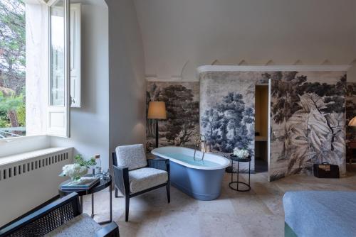 a bathroom with a blue tub and a painting on the wall at Palazzo Donna Elisabetta in Manduria
