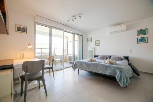 une chambre avec un lit, une table et un bureau dans l'établissement Marina Bay, à Antibes