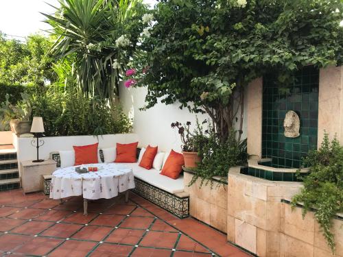 een witte bank met rode kussens op een patio bij Dar Esma in La Marsa