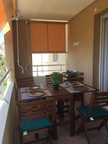 une salle à manger avec une table et des chaises en bois dans l'établissement Appartement T3 classé 3 étoiles vue mer avec terrasse ,plage 2 minutes à pied, à Ajaccio