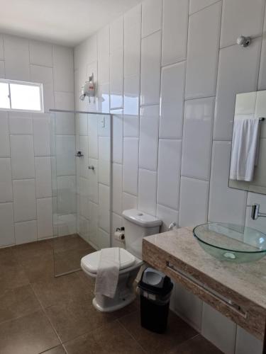 a white bathroom with a toilet and a sink at Lacazzona Hotel in Belo Jardim
