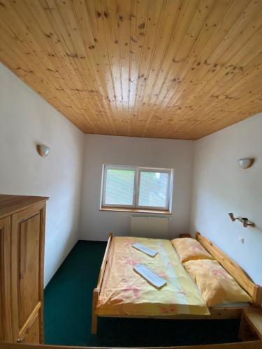 a bedroom with a bed with a wooden ceiling at Penzion pod Brehom in Terchová