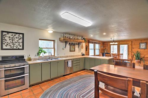 a kitchen with green cabinets and a wooden table at The Pinecone Palace with Hiking Trail Access! in Lyons