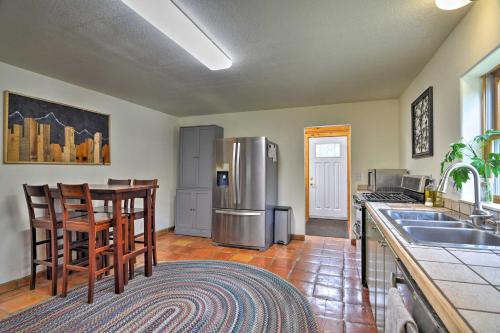 a kitchen with a stainless steel refrigerator and a table at The Pinecone Palace with Hiking Trail Access! in Lyons