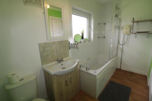 a bathroom with a sink and a tub and a toilet at Raynald House in Sheffield