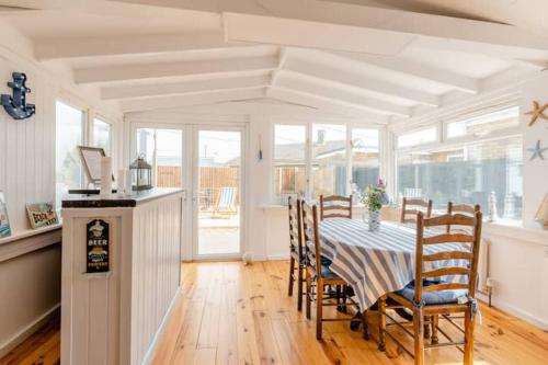 a dining room with a table and chairs at Dog friendly beachside cottage 2 mins to beach with hot tub in Lessingham