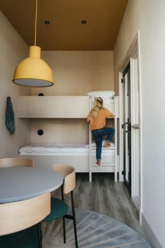 a woman sitting on a bunk bed in a room at Hotel Bries Den Haag - Scheveningen in The Hague