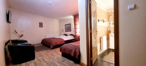 a hotel room with two beds and a bathroom at Pensiunea Oliver in Orşova