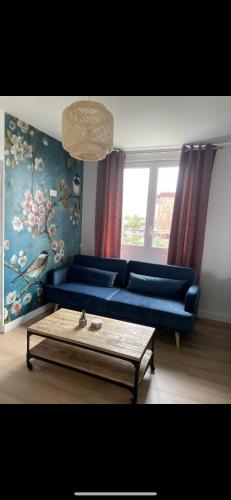 un salon avec un canapé bleu et une table dans l'établissement Villa saint Louis 4, à Cabourg
