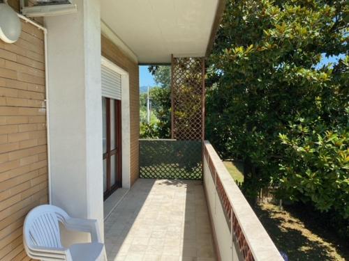 a white chair sitting on a porch of a house at B&B Tra Mare e Marmo in Marina di Carrara