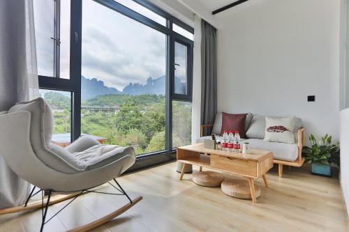a living room with a chair and a couch and a table at Heaven's Gate Home Stay --free pick up service--panoramic view of Tianmen Mountain in Zhangjiajie