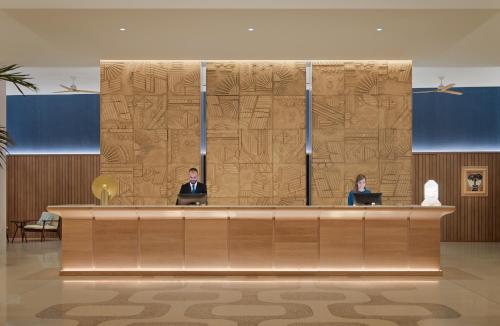 two people sitting at a reception desk with their laptops at H10 Porto Poniente 4* Sup in Benidorm