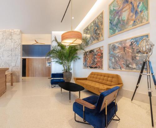 a living room with a couch and chairs and paintings at H10 Porto Poniente 4* Sup in Benidorm
