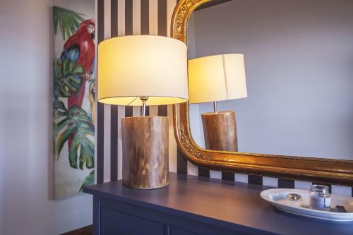 two lamps on a table in front of a mirror at Quinta da Morgadia - Azorean Butler in Feteiras