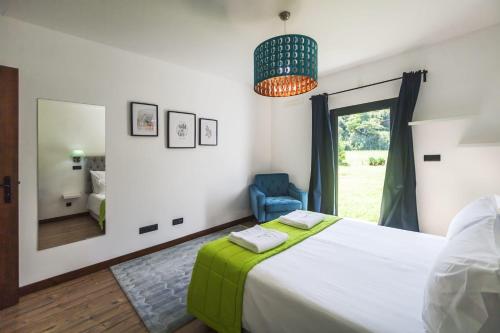 a bedroom with a large bed and a mirror at Quinta da Morgadia - Azorean Butler in Feteiras