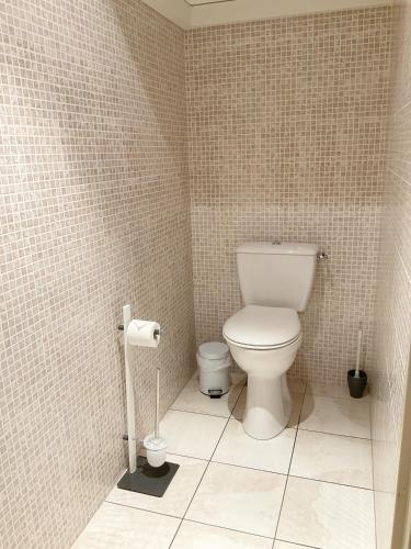 une salle de bain avec toilettes et un mur carrelé dans l'établissement Appartement de vacances - VILLA L'OLIVIER, à Vaux-sur-Mer