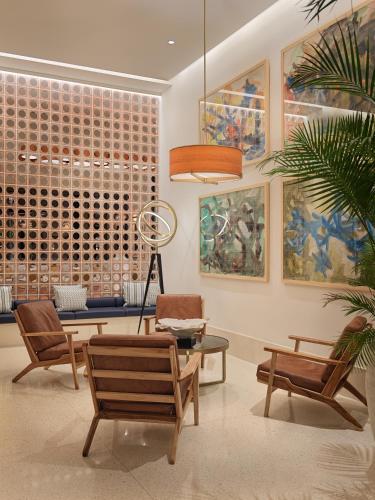 a living room with a table and chairs and paintings at H10 Porto Poniente 4* Sup in Benidorm