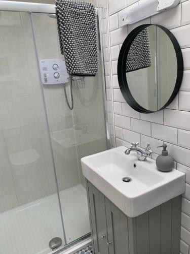 a bathroom with a sink and a shower with a mirror at Traditional Farm House in the Old Head of Kinsale in Cork