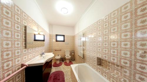 a bathroom with two toilets and a tub and a sink at Refined Villa near Catanhede with Private Pool in Cantanhede