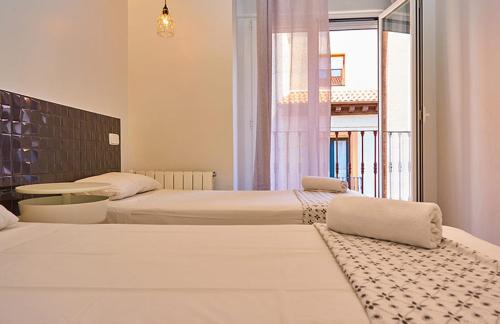Madrid Gran Vía, Behap Apartments في مدريد: غرفة نوم بسريرين وطاولة ونافذة