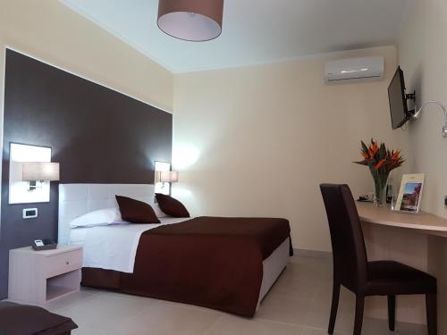 Un dormitorio con una cama y un escritorio con una silla. en B&B Villa Valentina, en Taormina