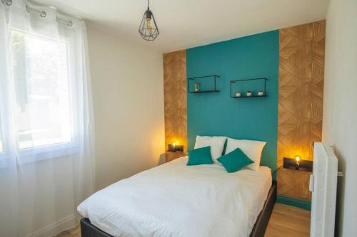 une chambre avec un lit avec un mur bleu dans l'établissement HOME GANUSHA COSY 3 CHAMBRES PARKING GRATUIT BALCON, à Grenoble