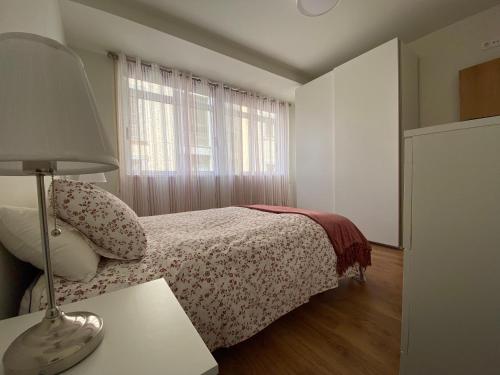 a bedroom with a bed and a table with a lamp at Cedemar 1 in Cedeira