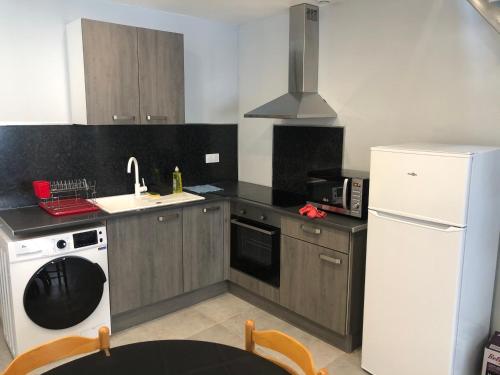 une cuisine avec un réfrigérateur blanc et un évier dans l'établissement Appartement en centre ville, à Hyères