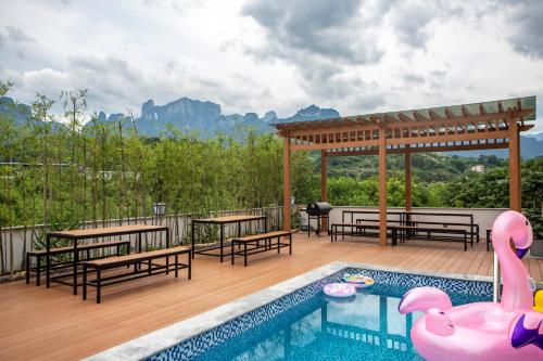 a swimming pool with benches and a deck with a swimming pool at Heaven's Gate Home Stay --free pick up service--panoramic view of Tianmen Mountain in Zhangjiajie