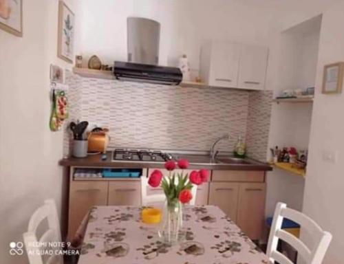 a kitchen with a table with a vase of flowers on it at Casa Vico Lepre in Noto