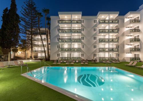 a hotel with a swimming pool in front of a building at Roca Verde - Playa del Inglés in Playa del Ingles