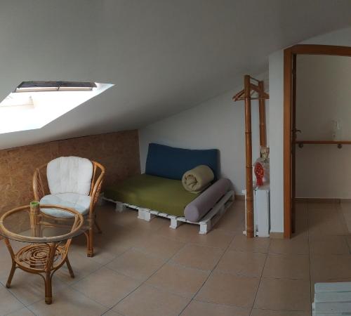 a room with a bed and a chair and a window at Green House in Baleal