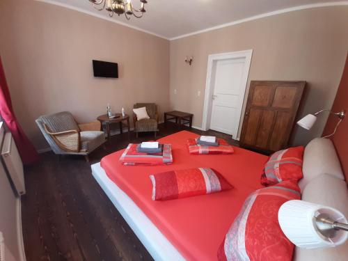 a room with a bed with a red blanket at Pension Havana Club in Weimar